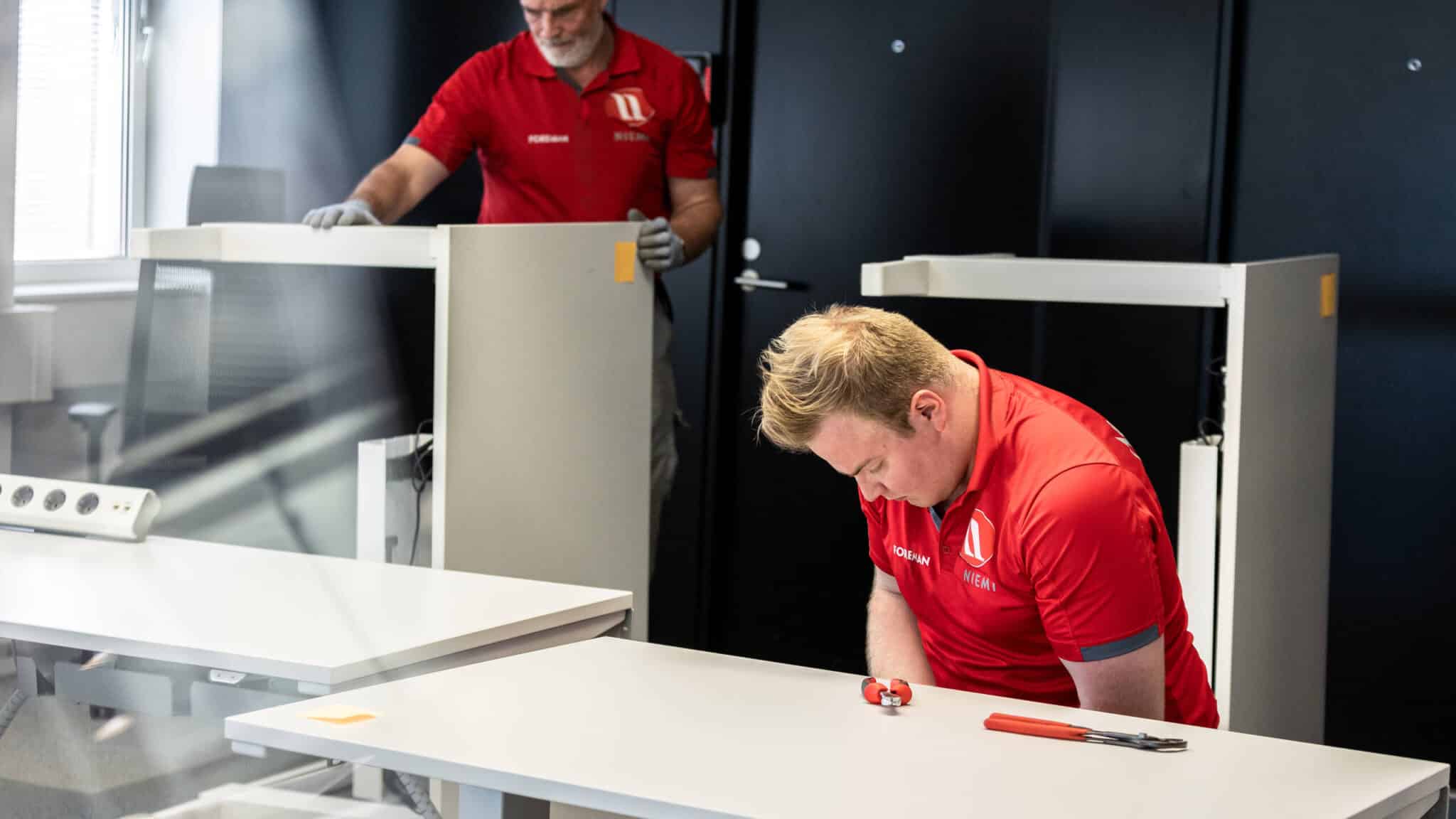 Pöytien asennusta toimistomuutolla