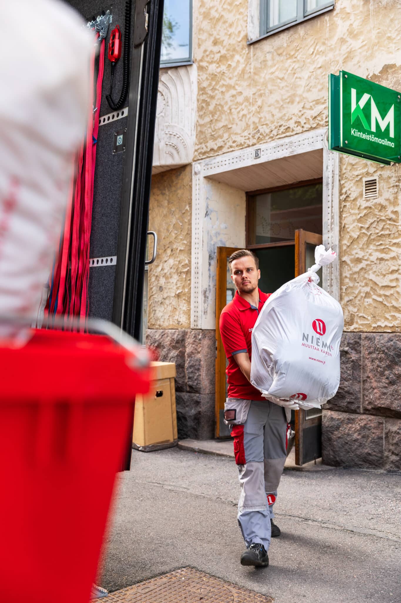 Muuttaja kantaa vaatepussia